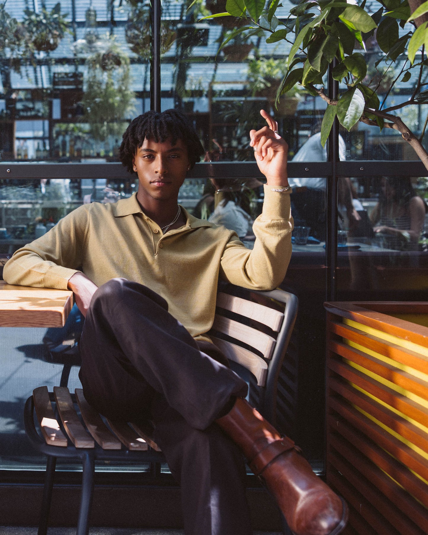 Mekonnen Knife sitting at a table in a cafe with plants in the background